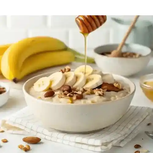 Banana Overnight Oats topped with sliced bananas, nuts, and a drizzle of honey, set against a bright kitchen background.