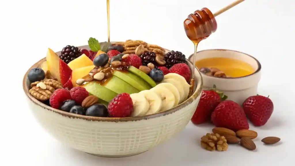 A colorful Fruit & Nut Bowl with Honey Drizzle featuring fresh fruits and nuts.